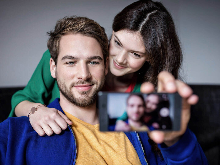 Mann und Frau machen ein gemeinsames Selfie mit einem Mobiltelefon.