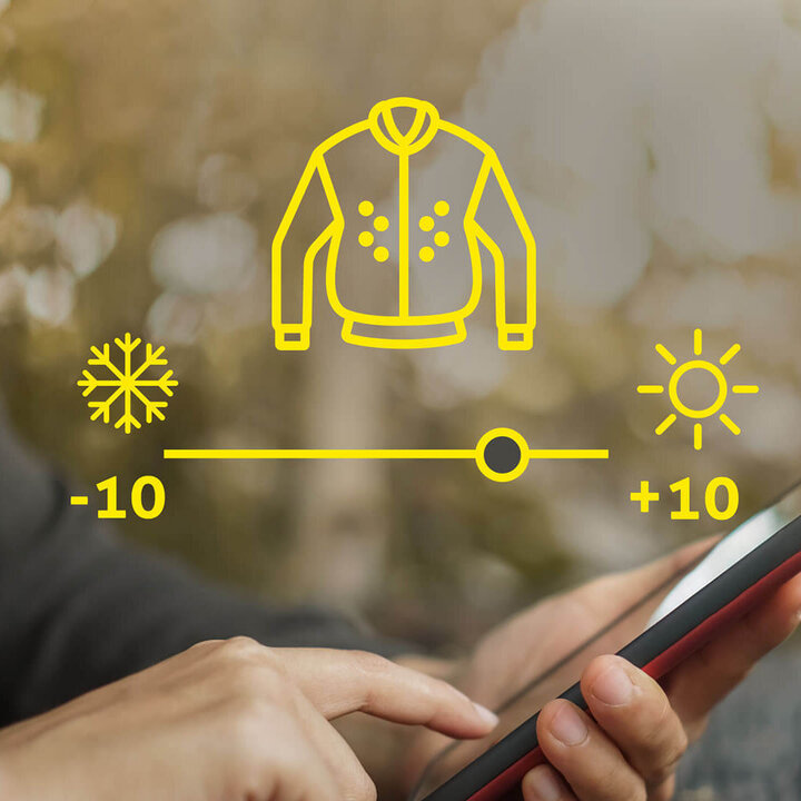 Grafische Darstellung der Wärmeeinstellung einer Jacke von -10 bis +10 Grad Celsius über ein Handy. Eine Hand hält das Handy, die andere Hand tippt.