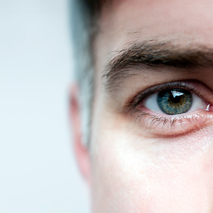 Anschnitt eines Männergesichts mit Fokus auf das Auge.