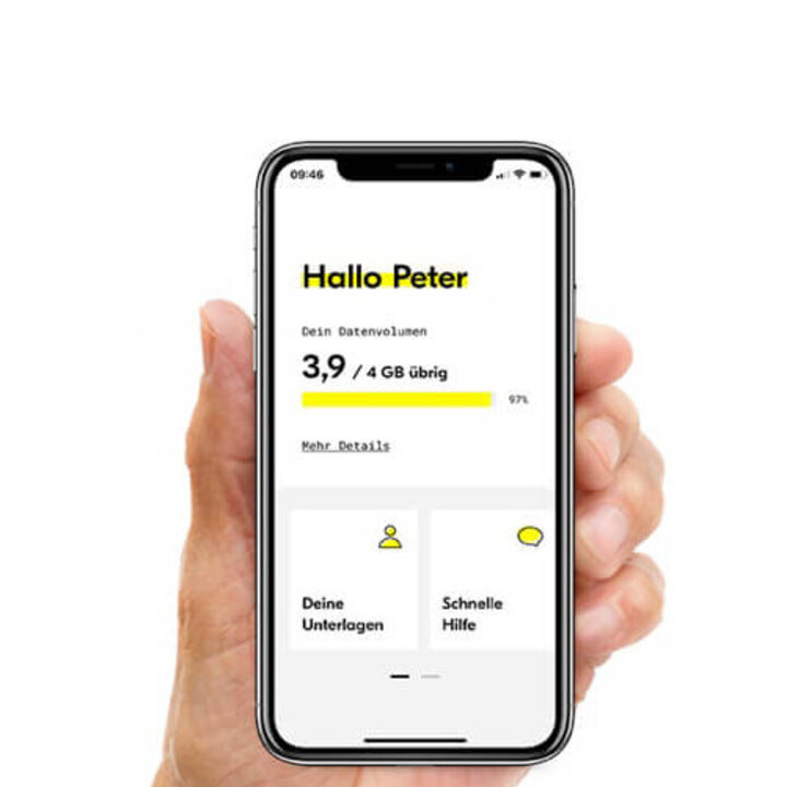 Eine Hand hält ein Mobiltelefon auf dem die fraenk App läuft. Der Screen zeigt "Hallo Peter".