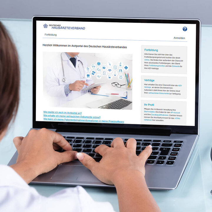 Eine Ärztin tippt auf einer Tastatur und sitzt vor einem Desktop, der das Ärzteportal zeigt.
