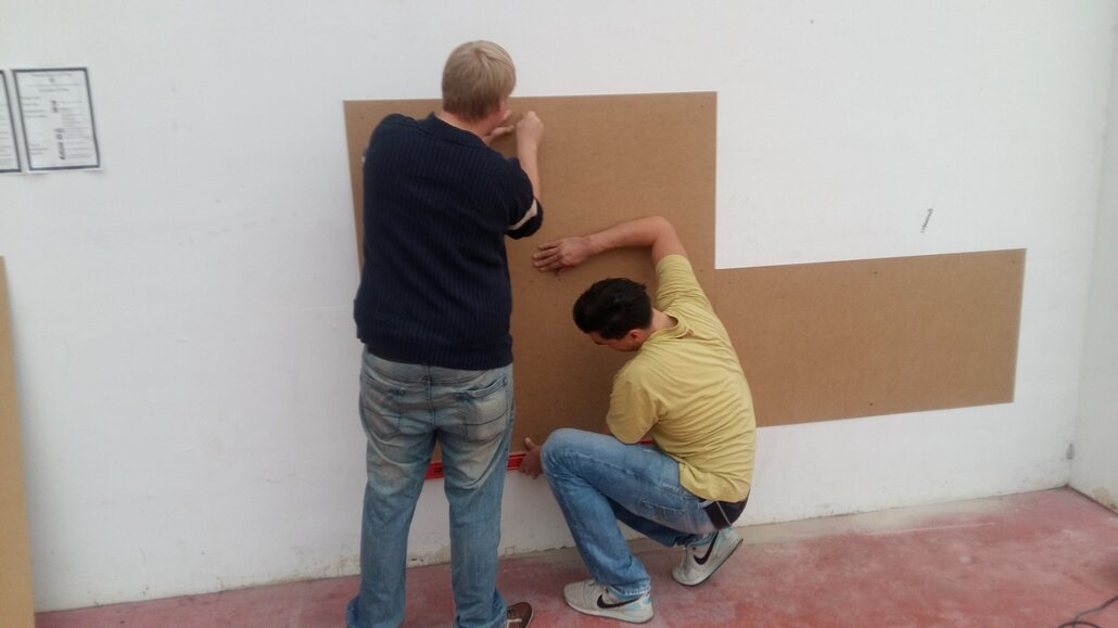 David Göhring und Robert Überschar nehmen Maß und bereiten die Wände für den Anstrich vor.