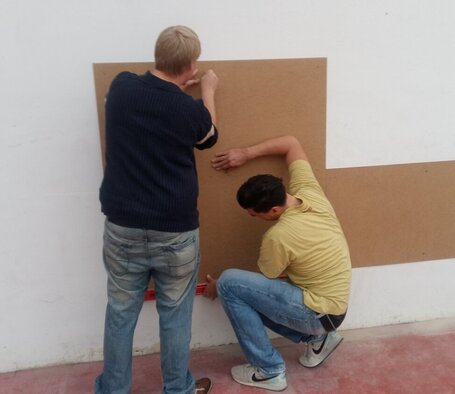 David Göhring und Robert Überschar nehmen Maß und bereiten die Wände für den Anstrich vor.