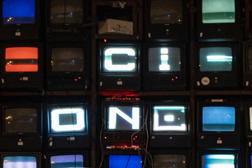 CI One wird als Schriftzug auf einer Monitor-Kunstinstallation dargestellt.