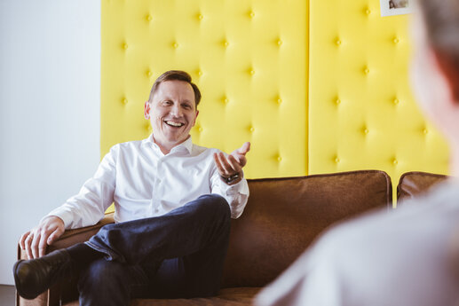 Matthias Schmidt Geschäftsführer Couch gelb Mann in weißen Hemd