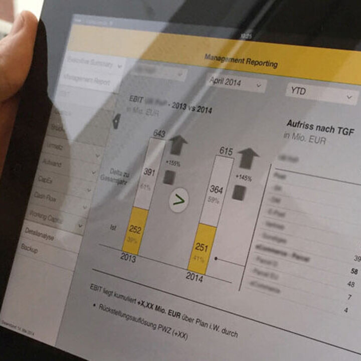 Ein User hält ein Tablet auf dem eine Anwendung für das Management Reporting läuft.